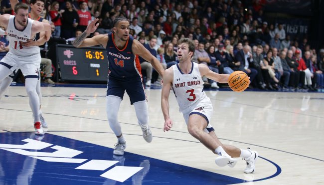 Men's Basketball player Augustas Marciulionis drives against Pepperdine in February 2024, while a defender tries to stop him