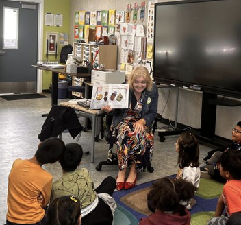 Dr. Wendi Aghily in a classroom reading to students