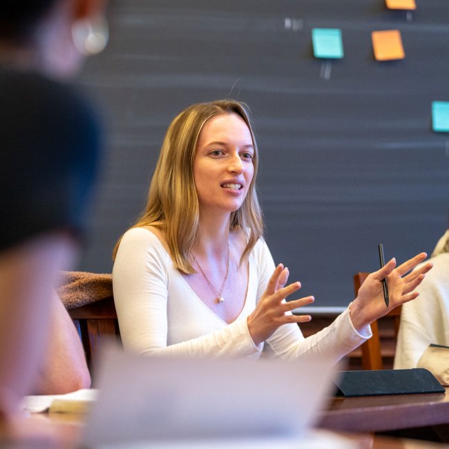 A student gesturing with her hands while talking