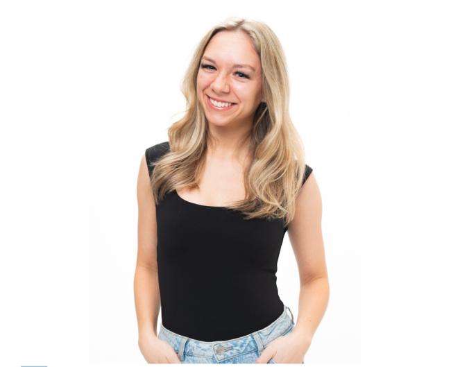 Blonde woman in black shirt in front of a white background.