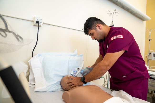 Male nursing student practicing in the simulation lab