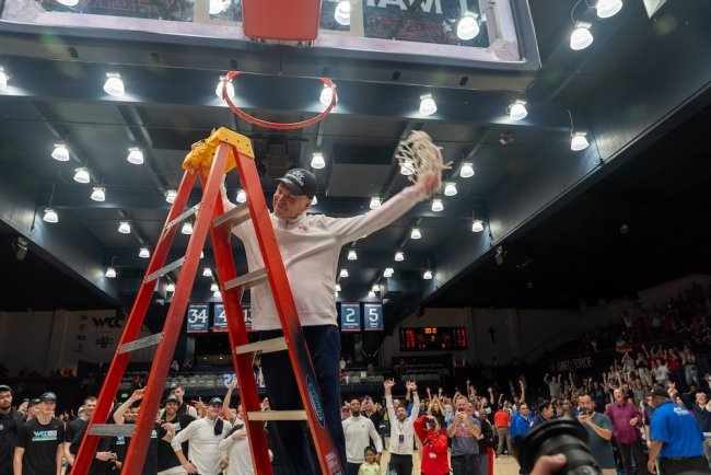 Basketball Coach Randy Bennett trims the net to celebrate winning the WCC Title in 2026