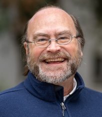 Headshot of Carl Thelen, smiling like a lunatic