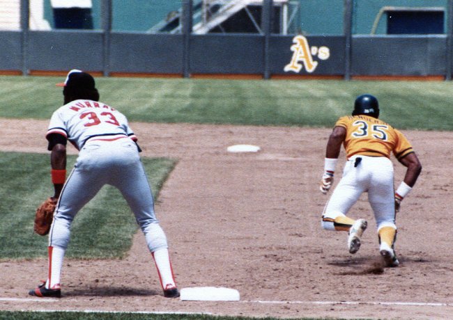 Baseball player Rickey Henderson stealing second