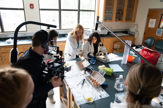 Sonya Schuh and student researcher with film crew in the lab in December 2026