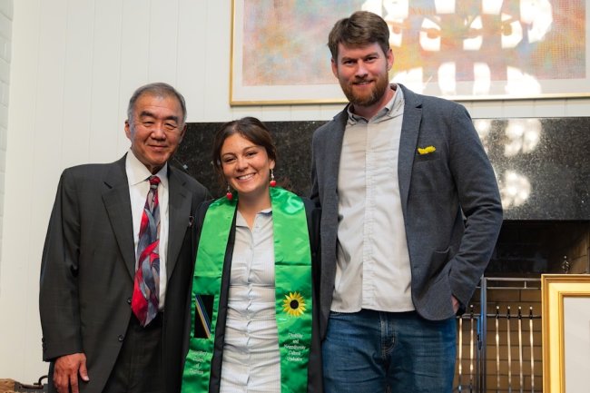 Three people standing: Professor Keith Ogawa, student Naomi Jordan, and Associate Professor James McCauley  at the Disability &amp; Neurodiversity Graduate Celebration in May 2026
