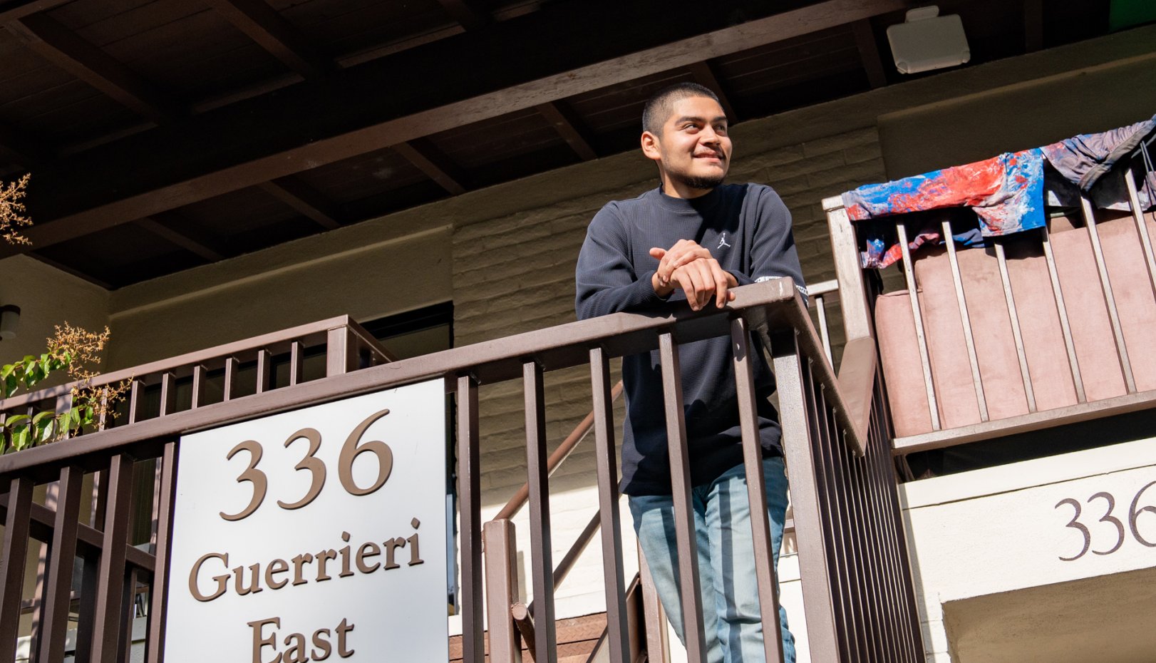 First-generation student Mat Escalante on the balcony of Guerrieri East, his residence hall