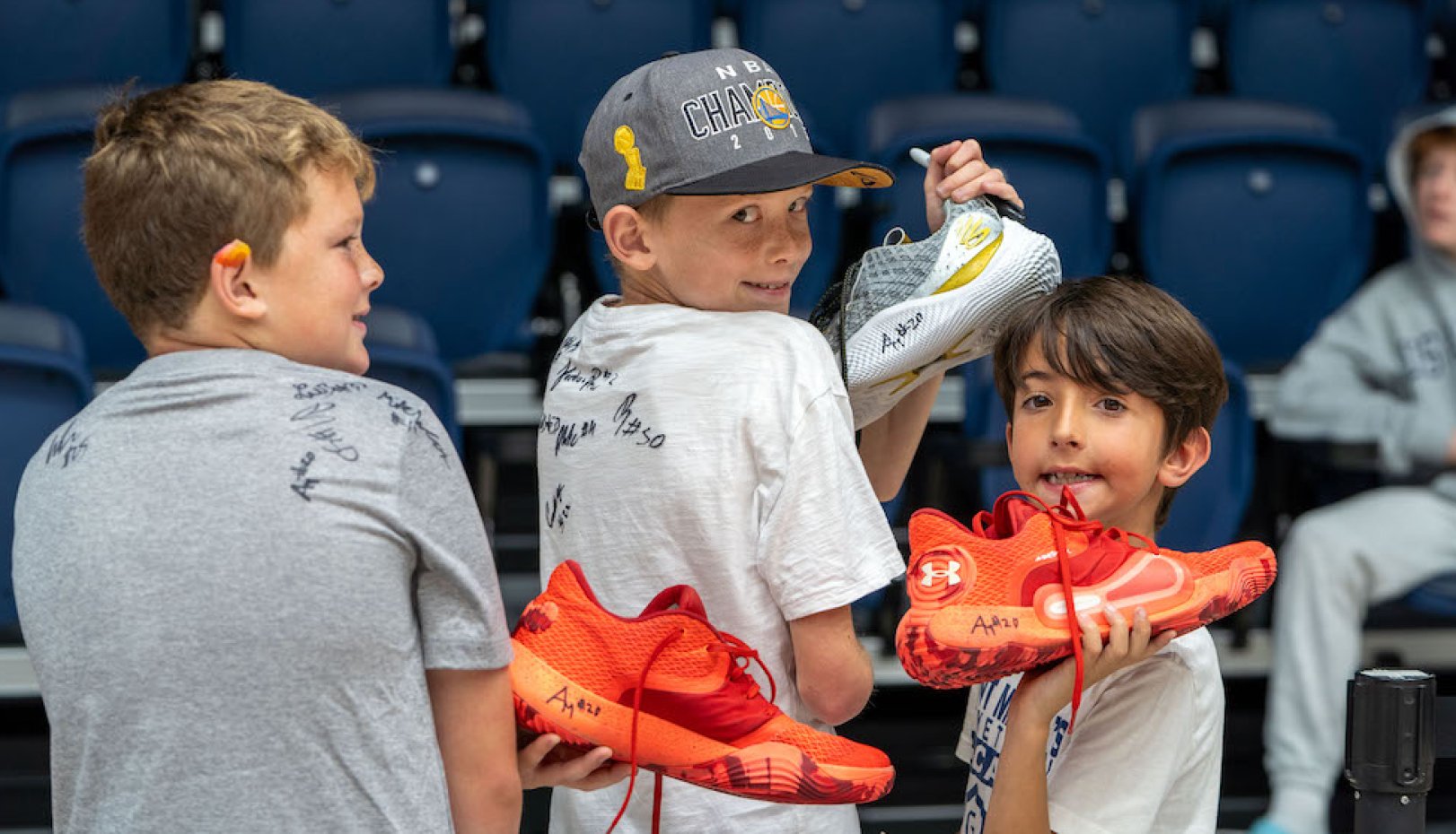 Young fans with autographed gear at 2024 NCAA Selection Sunday