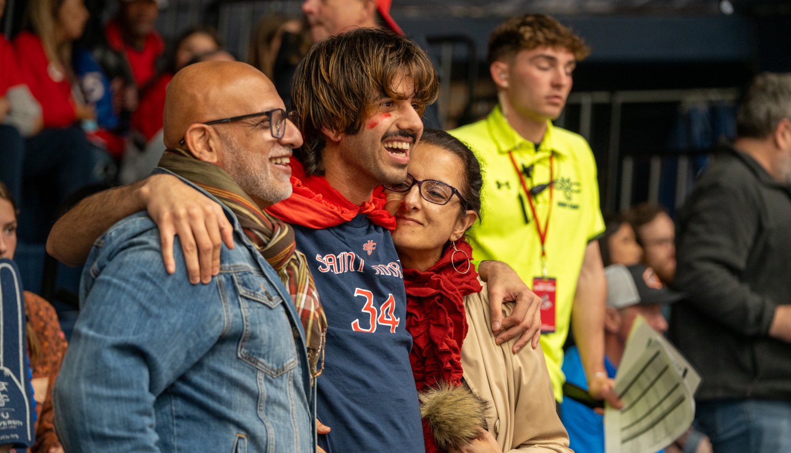 Student with parents smiling at men's basketball game vs. Gonzaga 2024