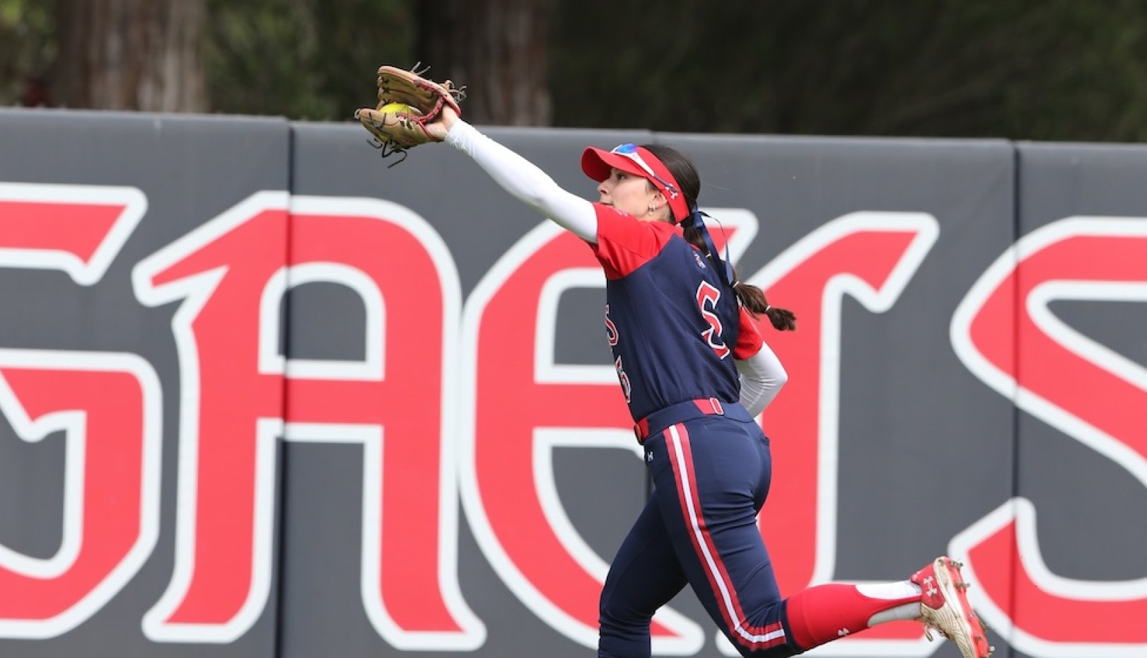 Softball player catches a fly ball