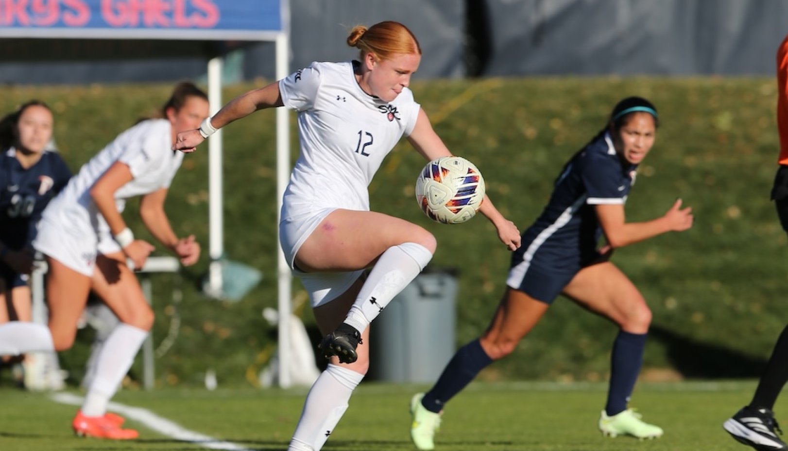 Women's soccer player kicks a ball