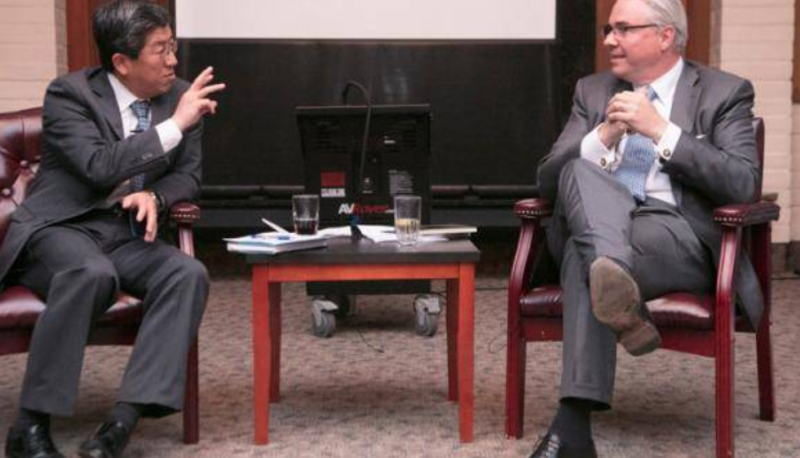 two men in suits sitting in chairs