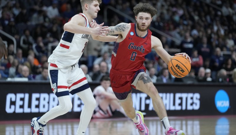 SMC basketball player Logan Johnson drives against a University of Connecticut player in NCAA tournament on March 19, 2023