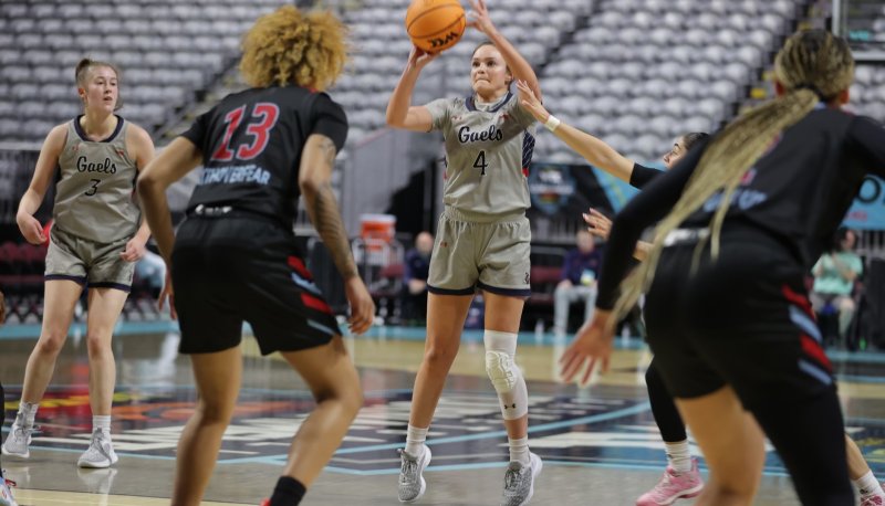 Taycee Wedin shoots a 3-pointer while teammate Leia Hanafin looks on.