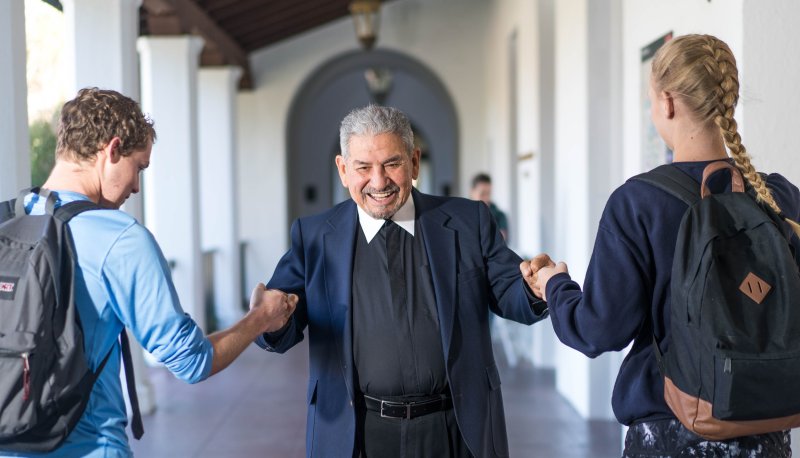 Brother Camillus giving fist bump to students