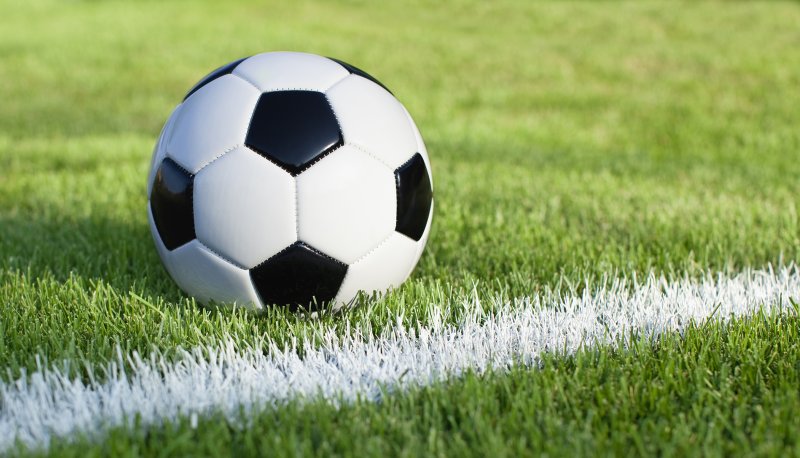 Soccer ball on field with stripe