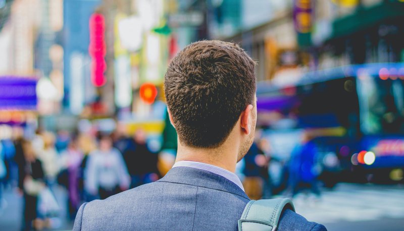 business man looking at blurry downtown street