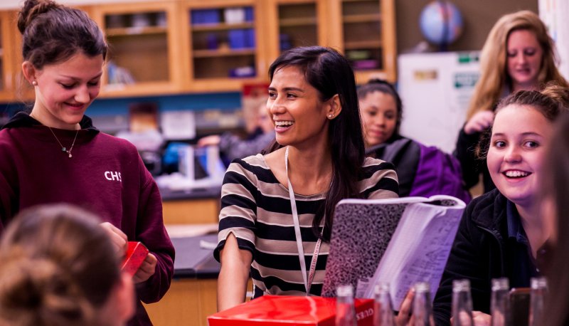 Female teacher with five students around her in science classroom