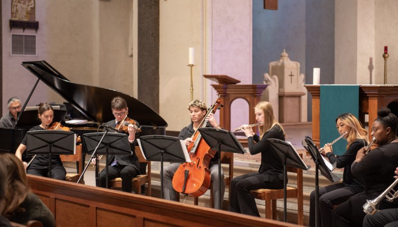 instrumental musicians perform dressed in black on the altar of SMC Chapel