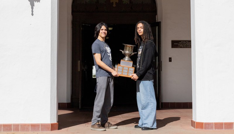 Adrian Lossada and Jasper Pacheco pose with the trophy on campus