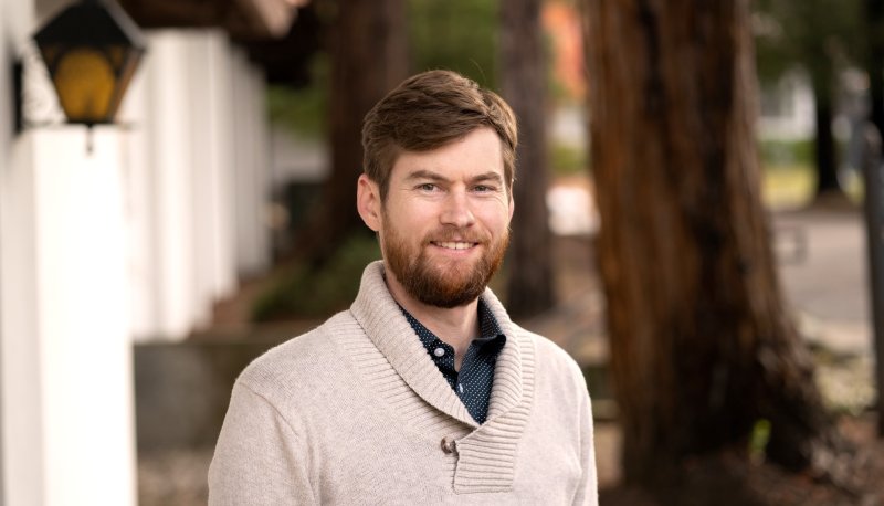 Profesor James McCauley next to redwood trees
