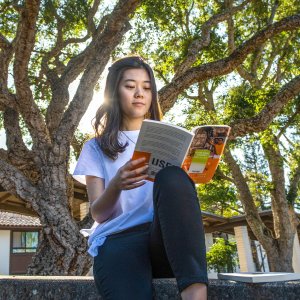 Student reads book on a sunny day