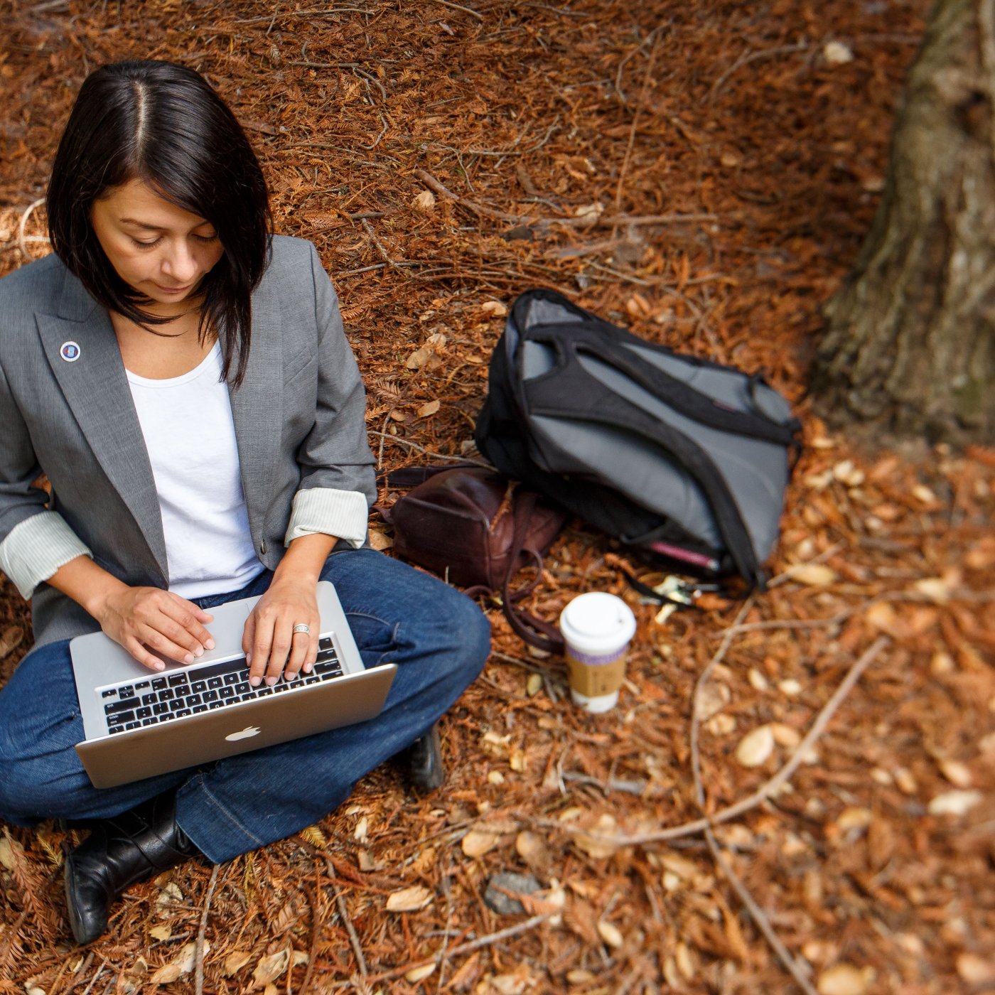 A student writes in the redwood grove.