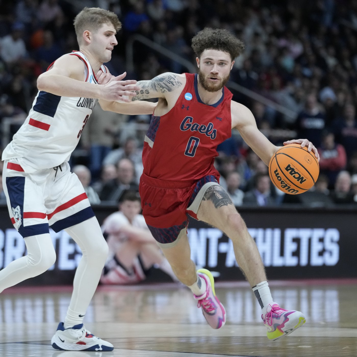 SMC basketball player Logan Johnson drives against a University of Connecticut player in NCAA tournament on March 19, 2023