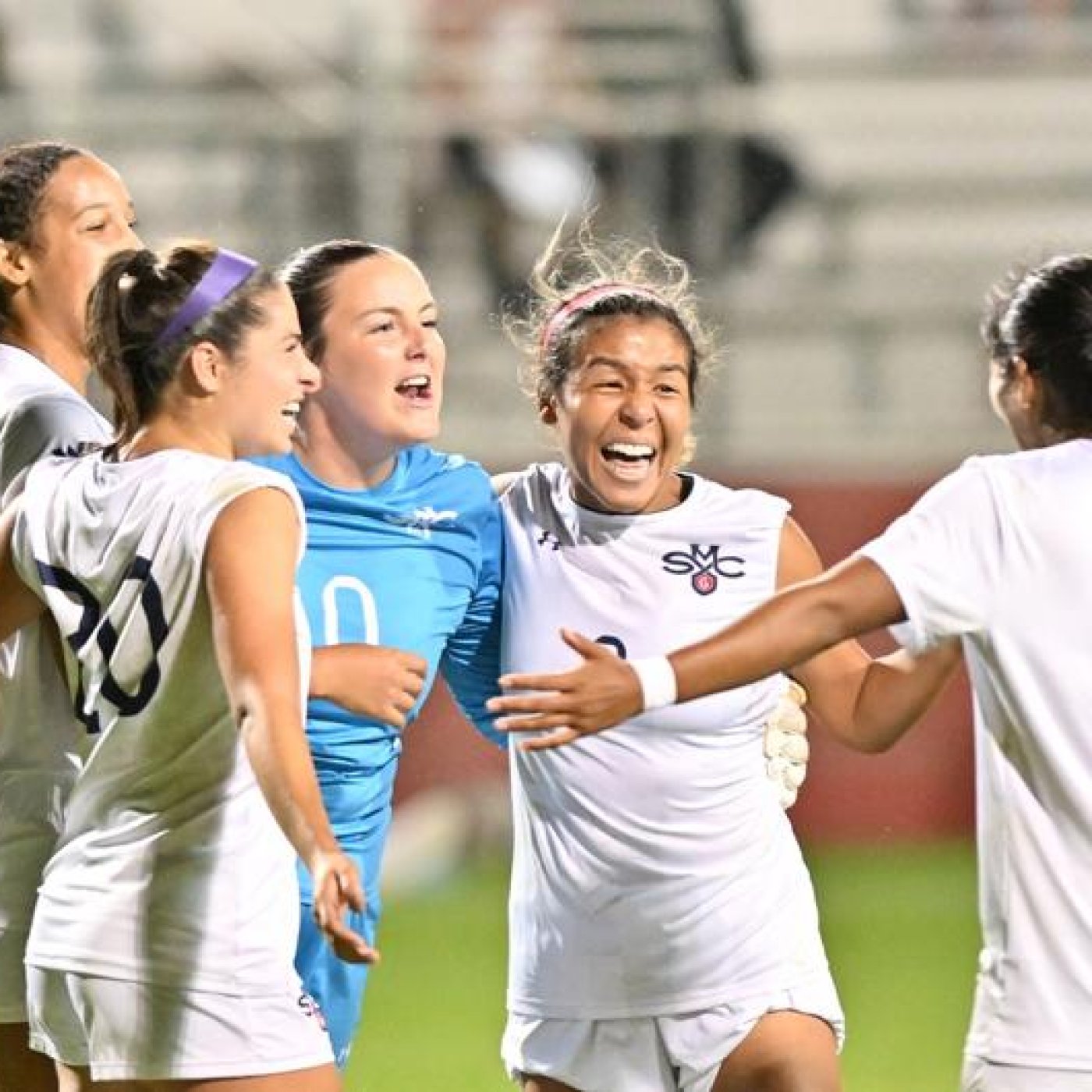 Five SMC women's soccer players celebrate in September 2023