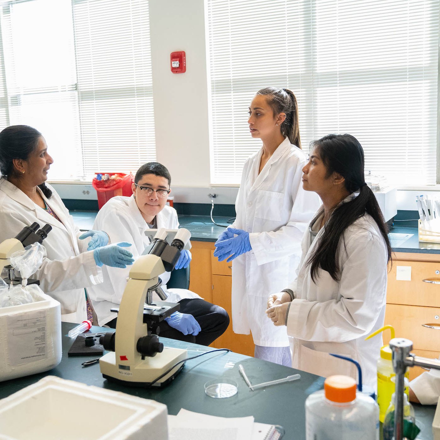Students listen to an instructor in the lab