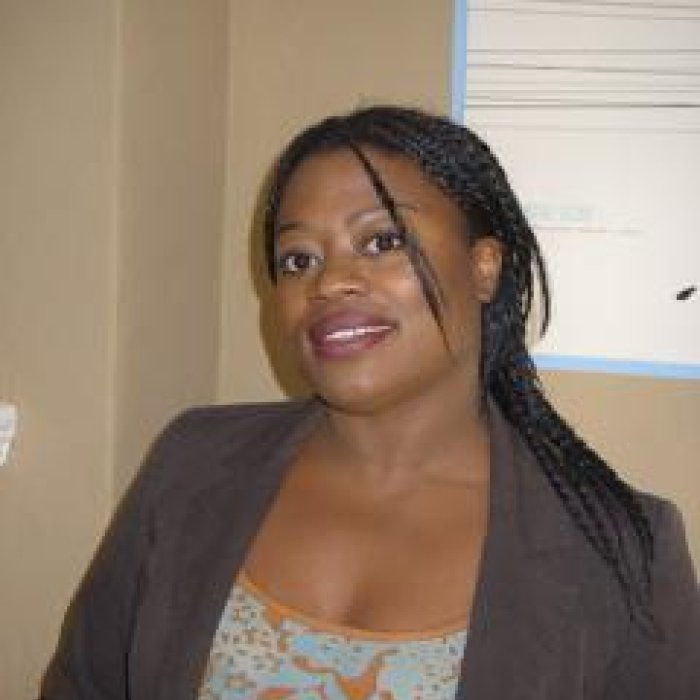 Headshot photo of Prof. Jeannine King in her office window in background