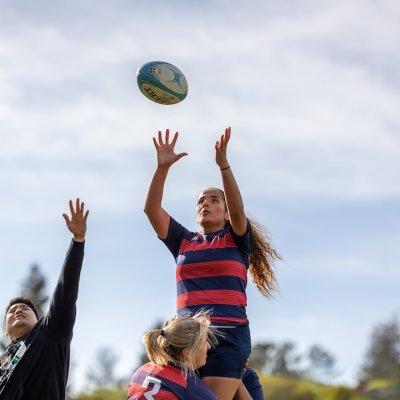 A women's rugby player reaching for the ball