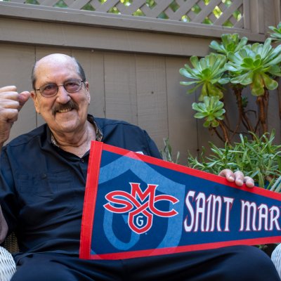 Tom Meschery holds an SMC pennant on his patio