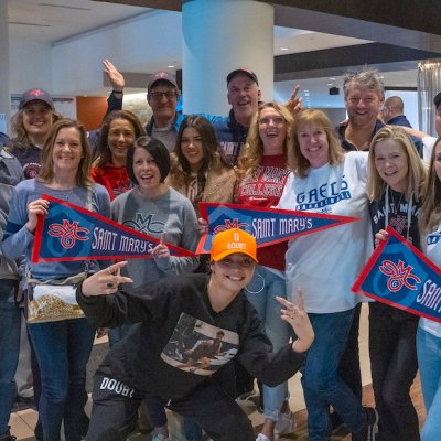 Fans smile and throw their hands in the air