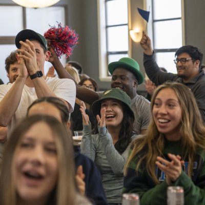 Students cheer at the 1928 Pub as they watch men's basketball beat VCU on March 17 2023