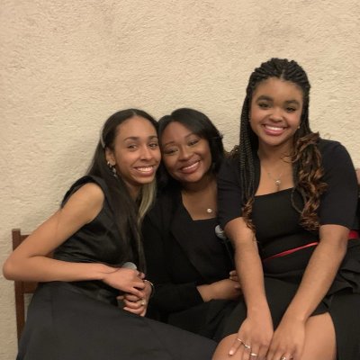 Three SMC females dressed in black dressy clothes smile at the camera.