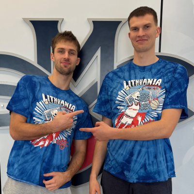 Men's basketball players Augustas Marciulionis and Paulius Marauskas in front of the SMC logo