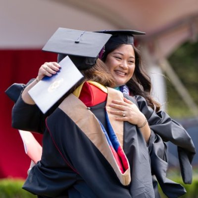 Student Samantha Mae Flores hugs another graduate at 2025 commencement