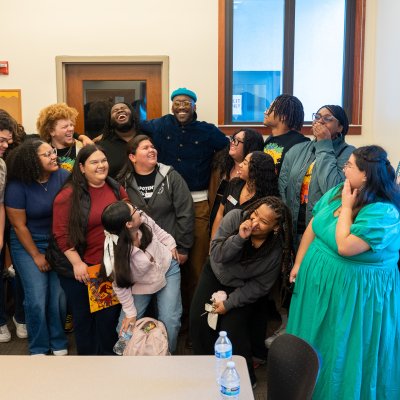 Mahershala Ali laughing with a dozen student scholars