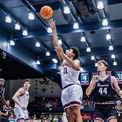 Basketball player Dillan Shaw shoots against Santa Clara in February 2026 while other players look on