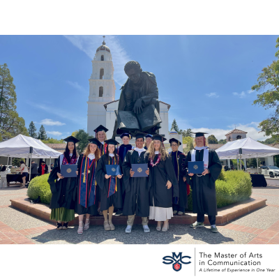 photo of blue sky and ma in comm graduates in black graduation gowns on the saint mary's campus