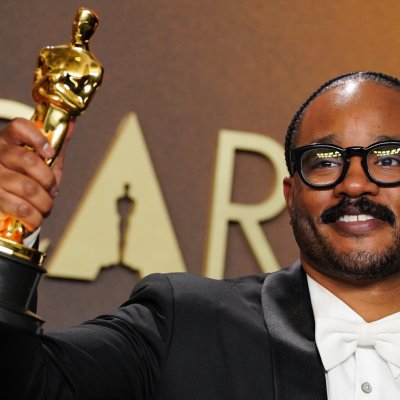 Ryan Coogler holding an Oscar aloft