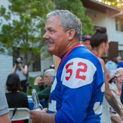 An alumnus wearing an old football jersey smiles during Reunion