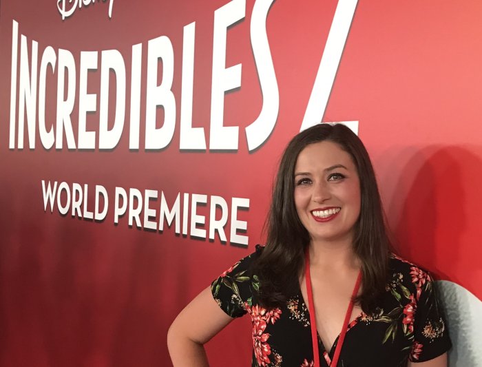 Alumna standing in front of a red backdrop for the Incredibles 2 movie premiere