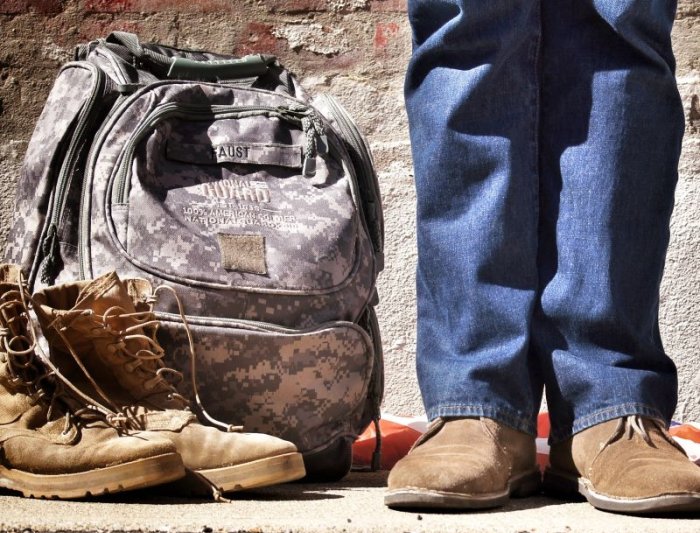 a military veteran standing next to books and backpack