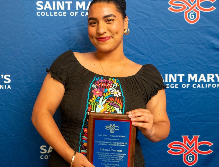Student Rebecca Carranza holds an awards plaque at 2024 Student Leadership Awards
