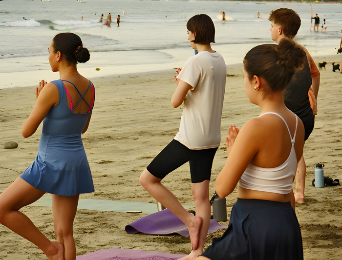 Students doing yoga on the beach
