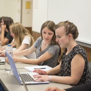 2 students in class looking at one laptop