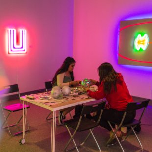 students making disco balls in the museum of art surronded by neon displays