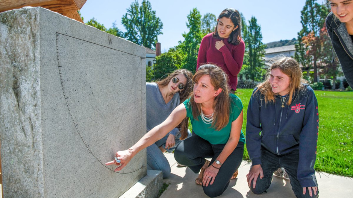 A professor demonstrating an angle on a plinth for students